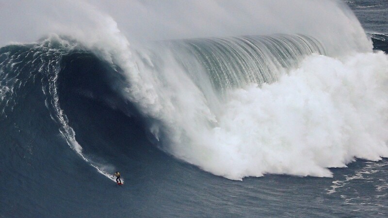 Im portugiesischen Nazaré entsteht wegen einer Unterwasserschlucht die größte surfbare Welle der Welt: Nun scheint eine ebenso mächtige Corona-Welle aus dem südeuropäischen Land auf Deutschland zuzurollen.