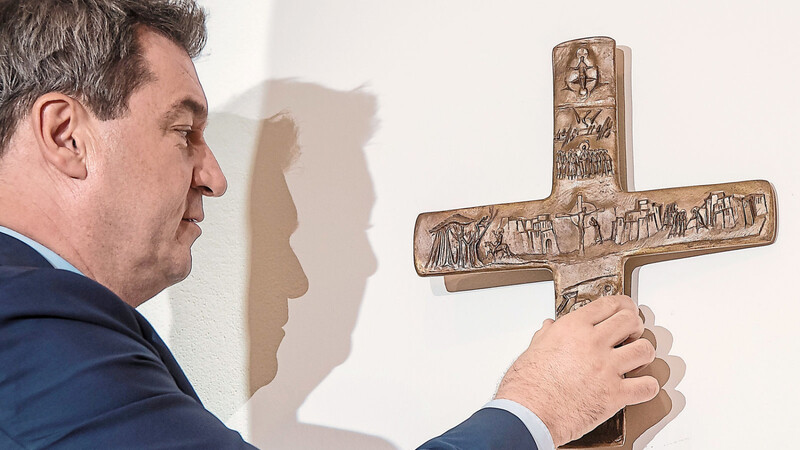 Bayerns Ministerpräsident Markus Söder (CSU) hängt ein Kreuz im Eingangsbereich der bayerischen Staatskanzlei auf. Der umstrittene Kreuzerlass der Staatsregierung wird ein Fall für den Bayerischen Verwaltungsgerichtshof.
