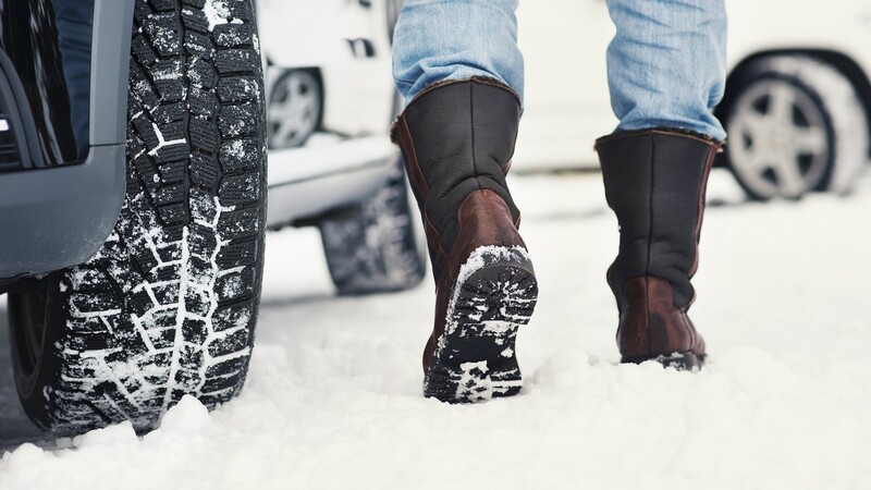 Vor der Autofahrt sollte der Fahrer seine Schuhe von Schnee befreien.