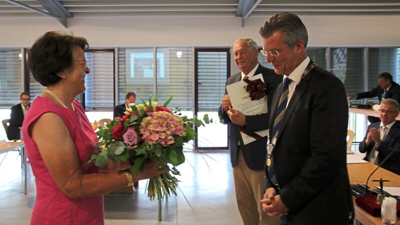 Erich Schmid nahm aus den Händen von Bürgermeister Hans Schmalhofer die beiden Auszeichnungen entgegen. Mit bunten Blumen gedankt wurde auch seiner Frau Karola.