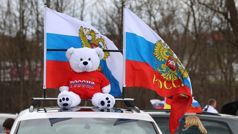 Ein Teddybär und russische Fahnen sind in Kaufbeuren an einem Auto montiert. Der Platz ist Ausgangspunkt eines prorussischen Autokorsos. Die Demo richtet sich laut Stadt gegen eine "Diskriminierung russischstämmiger Menschen". +++ dpa-Bildfunk +++