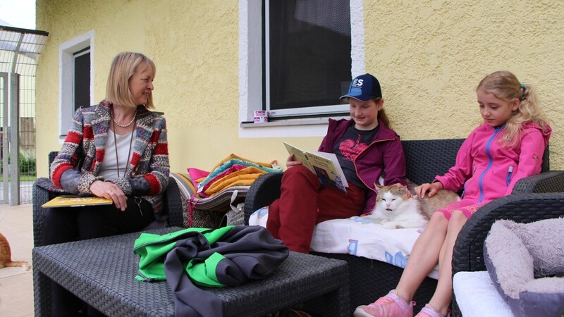 Christina (Mi.) liest einem der "Bewohner" der Katzenauffangstation vor, zuvor war Luisa dran. Rektorin Ulrike Nauen hört aufmerksam zu.