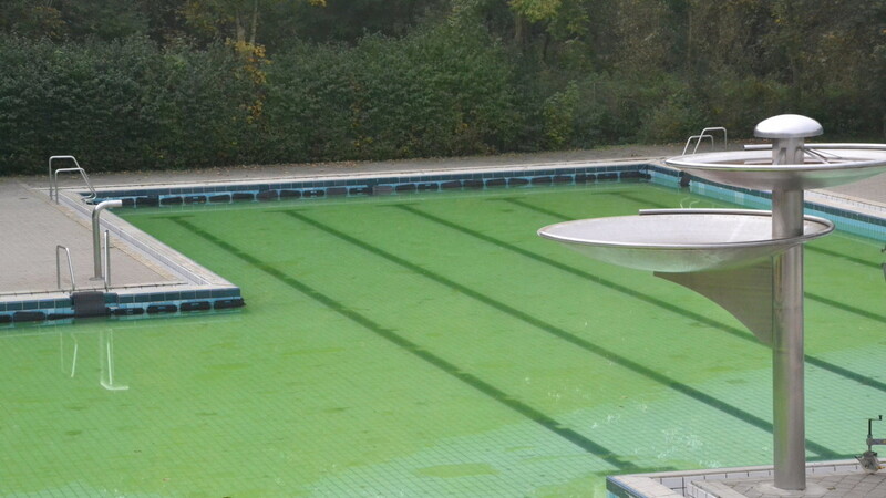 Eine grüne Oberfläche ziert das Rutschenbecken. Bis zum Beginn der neuen Freibadsaison bleibt das grün schillernde Wasser im Becken.