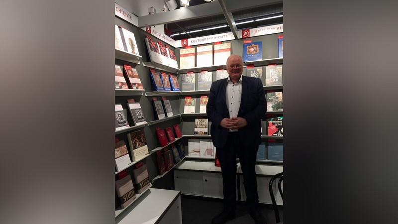 Vertriebs- und Marketingleiter Rainer Boos vor dem Messestand des Regensburger Verlags Schnell & Steiner.