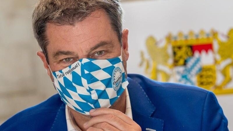 Markus Söder (CSU), Ministerpräsident von Bayern, trägt eine Mundschutzmaske im weiß-blauem Rautendesign auf. Foto: Peter Kneffel/dpa/Archivbild