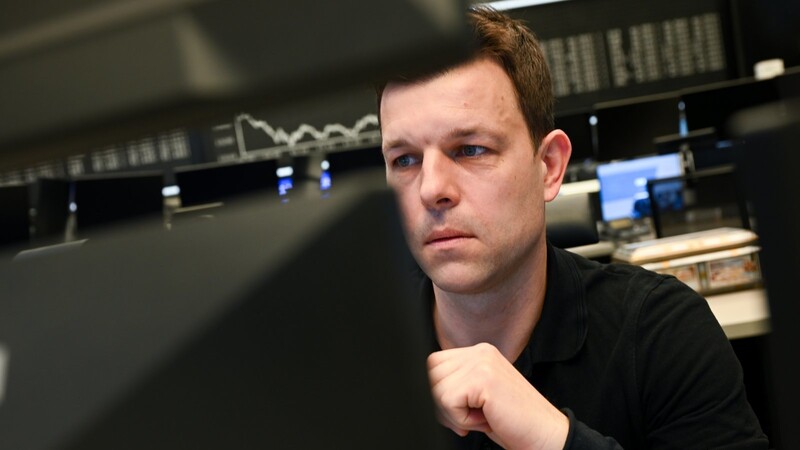 Eine Aktienhändler beobachtet im Handelssaal der Frankfurter Wertpapierbörse seine Monitore.