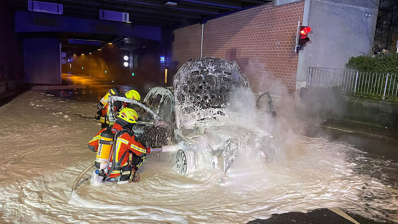 Mit Wasser und Löschschaum bekämpften Atemschutzträger der Landshuter Feuerwehr die Flammen, die von einem Auto am Tunnelportal zur Wittstraße ausgingen.