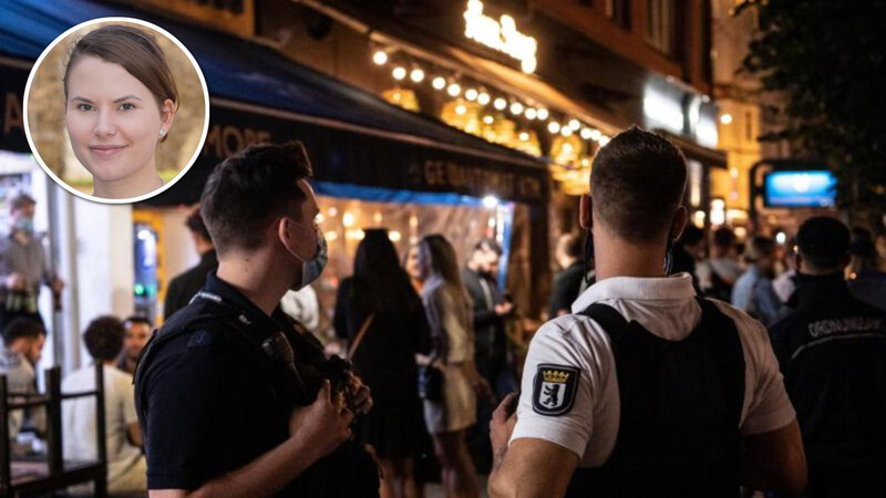 Vor einem Berliner Lokal kontrollieren Polizisten eine Party.