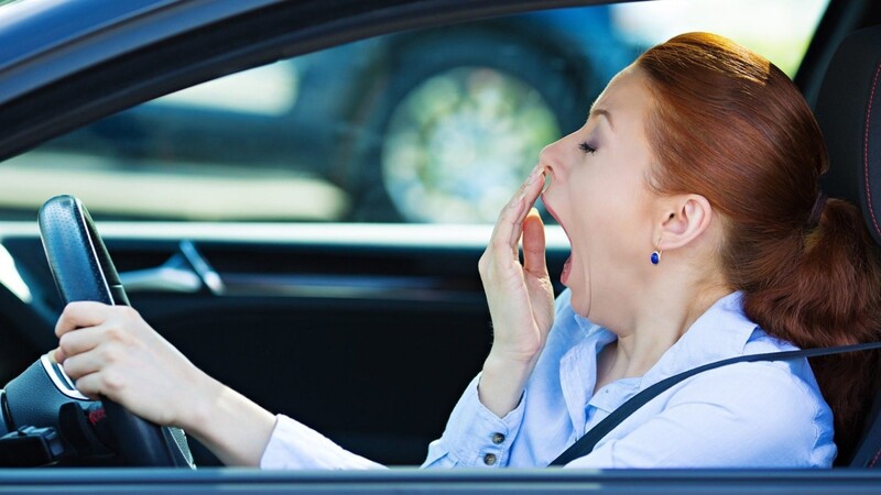 Eine Fahrerin gähnt am Steuer - Frauen macht die Zeitumstellung einer Umfrage zufolge mehr zu schaffen als Männern.