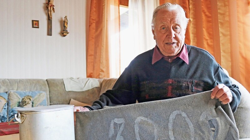 Zwei kleine Erinnerungen an die Kriegszeit: Josef Bauer mit der Decke eines KZ-Häftlings und einem Essgeschirr, das er damals aufgesammelt hat.