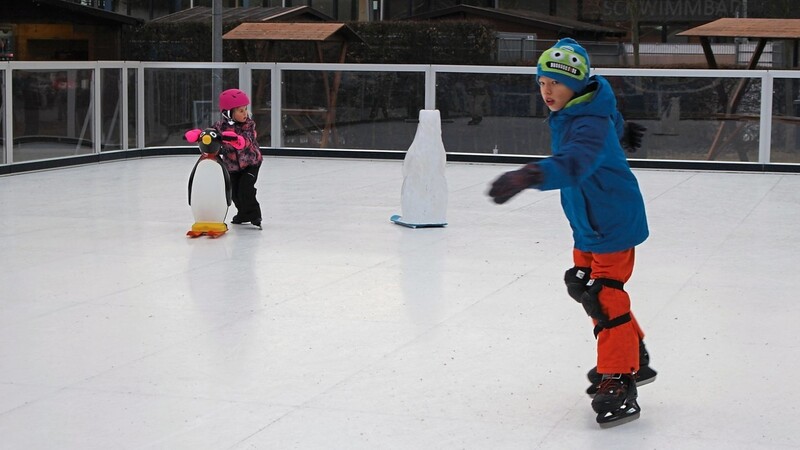 Eisläufer genießen das Gleitgefühl auf der Kunsteisfläche der Bergstadt.