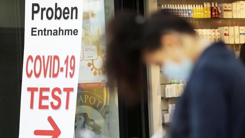 Eine Frau füllt vor einer Apotheke in Bonn ein Formular für einen Covid-19-Test aus.