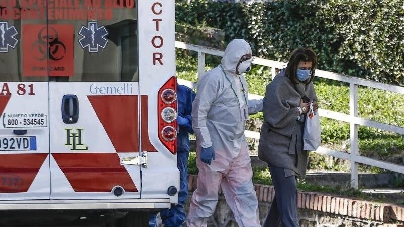 Ein medizinischer Angestellter begleitet in Rom eine Patientin ins Krankenhaus.