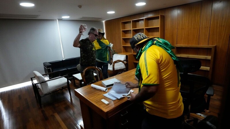 Bolsonaro-Anhänger wühlen sich in einem Büro des Palacio do Planalto, dem offiziellen Sitz des brasilianischen Präsidenten, durch Papiere.