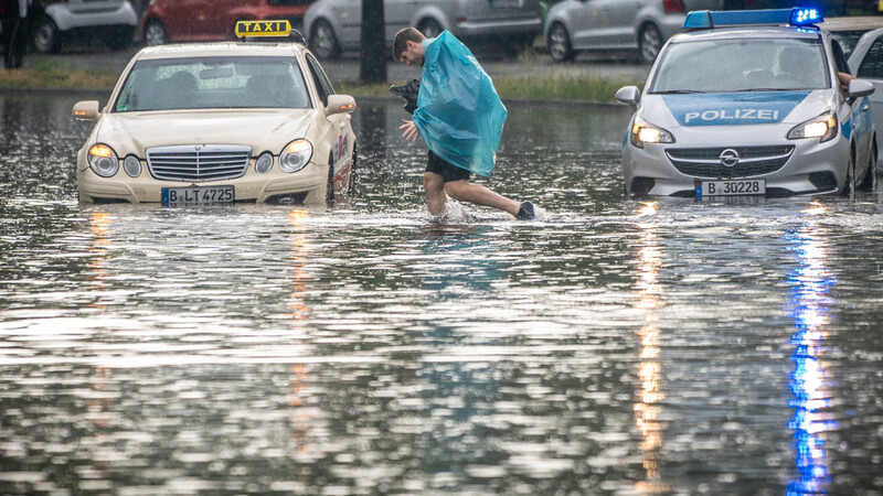 Ein Mann geht über die überflutete Tiergartenstraße in Berlin Mitte. Mehrere Autos blieben im teilweise Knietiefen Wasser liegen.