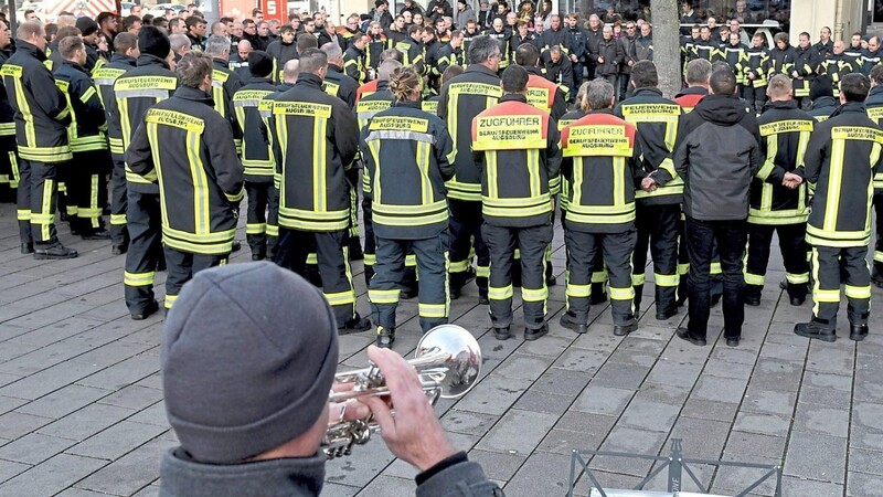 Dutzende Feuerwehrleute trauerten am Sonntag am Königsplatz in Augsburg um ihren Kameraden, der dort nach einem Streit von jungen Männern totgeschlagen worden war