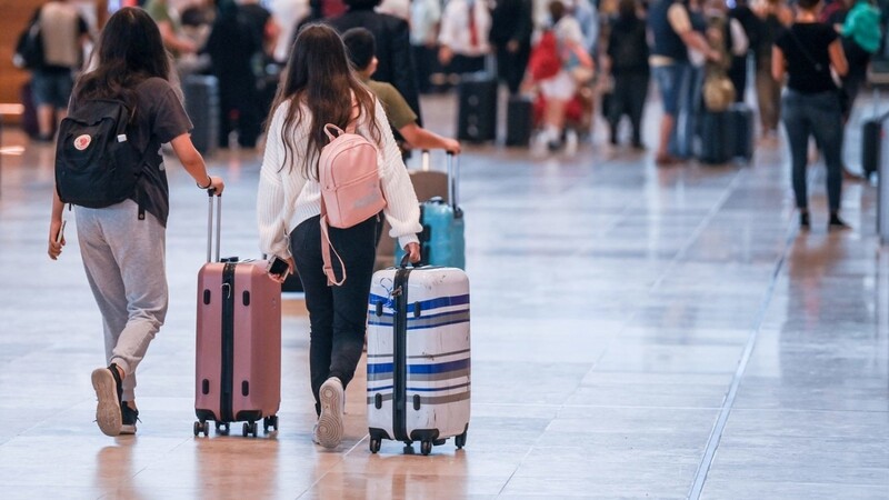 Reisende gehen im Flughafen Berlin-Brandenburg (BER) mit Koffern durch den Abflugsterminal. Die Delta-Variante breitet sich in vielen Ländern Europas aus.