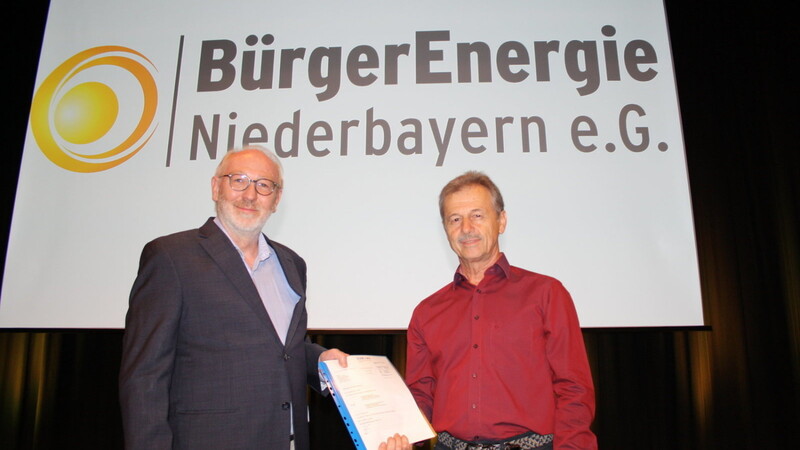 Klaus-Dieter Mack und Martin Hujber mit dem Gutachten zum Verschmelzungsvertrag. Außerdem wurde auch die Namensänderung in Bürgerenergie Niederbayern beschlossen.