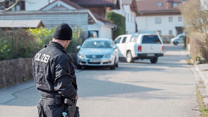 Der Tatort in Vogtareuth im Kreis Rosenheim: Ein Polizist steht auf der Straße vor dem Haus, in dem die drei Toten gefunden worden sind.