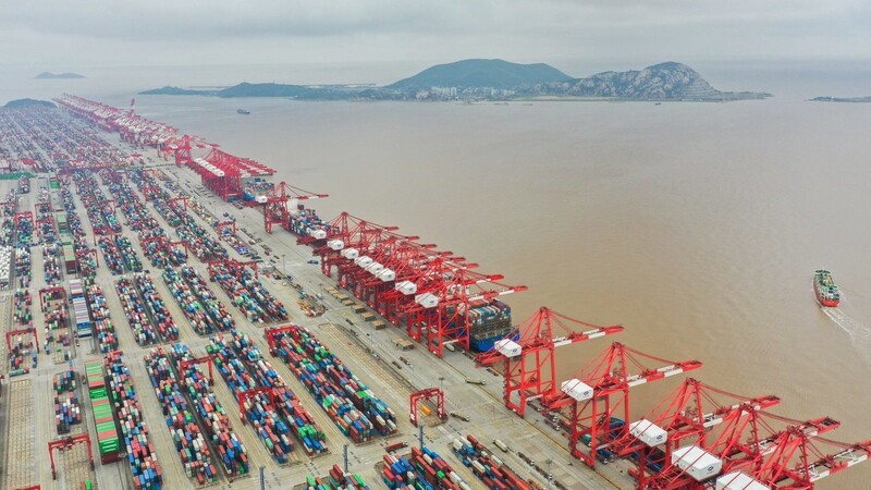 Blick auf Container und Kräne im Yangshan-Hafen. Der Frachtschiff-Stau in Shanghai wirkt sich auch auf die deutsche Wirtschaft aus.