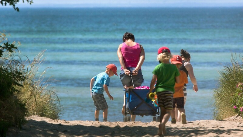 Wohin soll die Reise gehen? Wie wäre es mit Deutschland: Eine Familie zieht an den Strand von Timmendorf auf der Insel Poel.