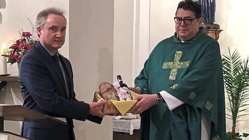 Kirchenpfleger Christoph Zistler beim Überreichen des Willkommensgeschenks