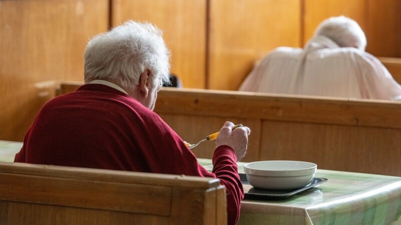 Zwei Senioren sitzen beim Essen in der Fürstlichen Notstandsküche im Schloss St. Emmeram in Regensburg. Dort werden bedürftige Menschen mit einem warmen Mittagessen versorgt. Sehr viele Menschen in Bayern erhalten eine Rente unterhalb der Armutsgefährdungsschwelle.