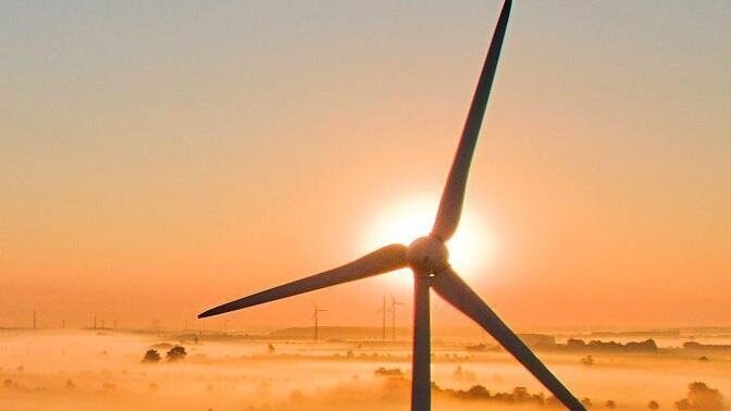 Für die einen der Horror, für die anderen ein Symbol für nachhaltige Energiewirtschaft: Windräder bei Sonnenaufgang mit Nebelfeldern.