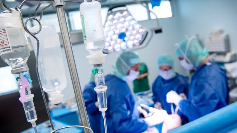 Ein Ärzteteam arbeitet in einem Operationssaal eines Krankenhauses. Wird in bayerischen Kliniken zuviel operiert?