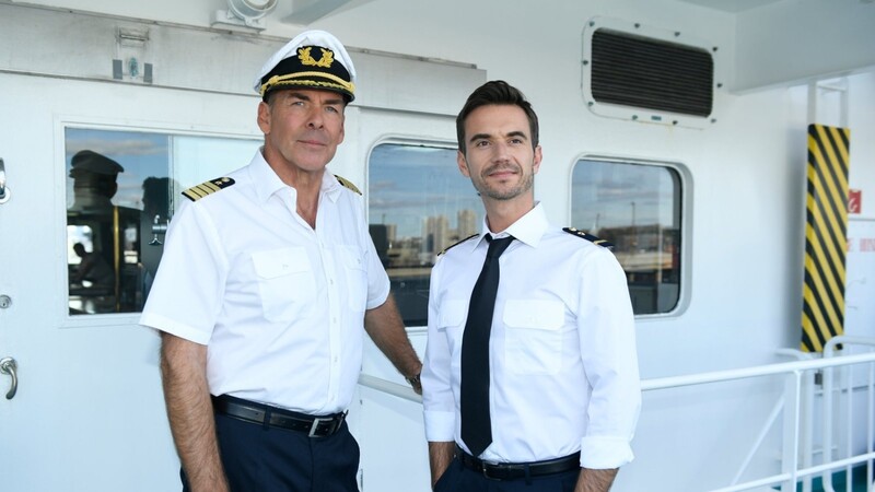 Kapitän Burger (Sascha Hehn, l.) und der junge Offizier Florian (Florian Silbereisen) stehen in der Folge "Das Traumschiff: Tansania" auf der Brücke des Schiffs.