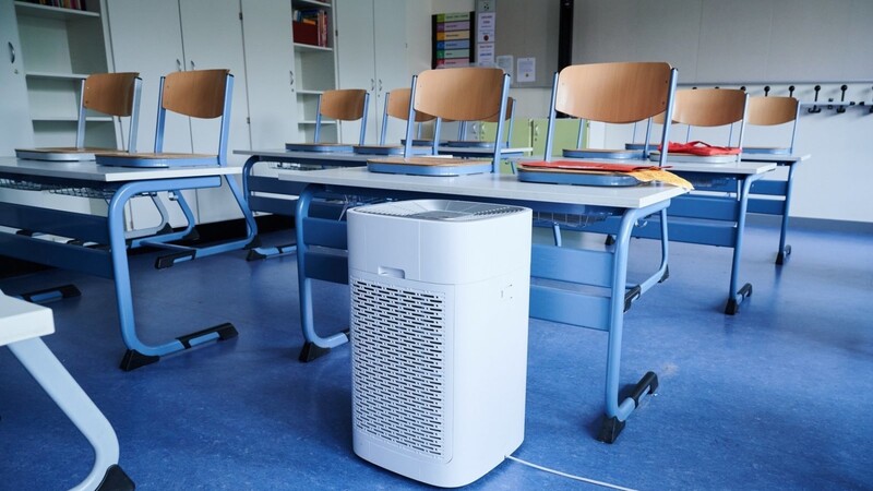 Ein Luftreinigungsgerät steht in einem Klassenraum einer Grundschule. Bayerns Kommunen werden in der Hinsicht von der Staatsregierung gerade vor eine Herausforderung gestellt.