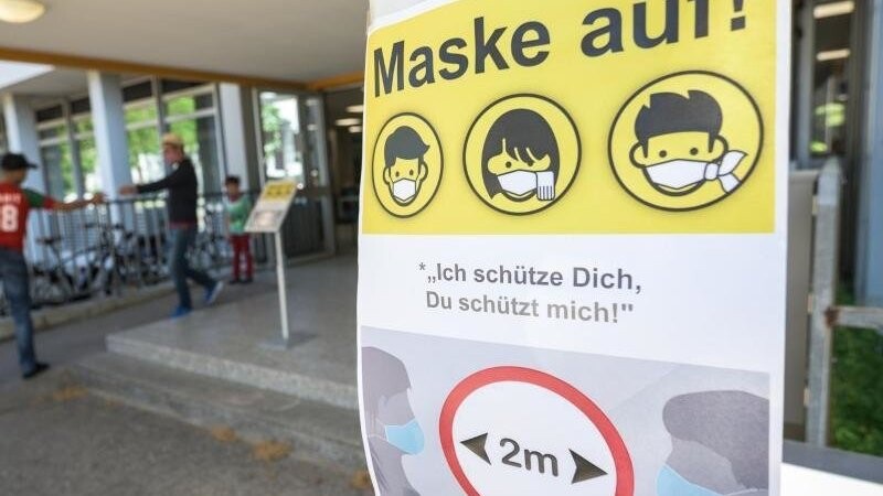 Ein Plakat weist auf die Maskenpflicht in einer Schule hin. In Bayern startet am 8. September wieder die Schule.