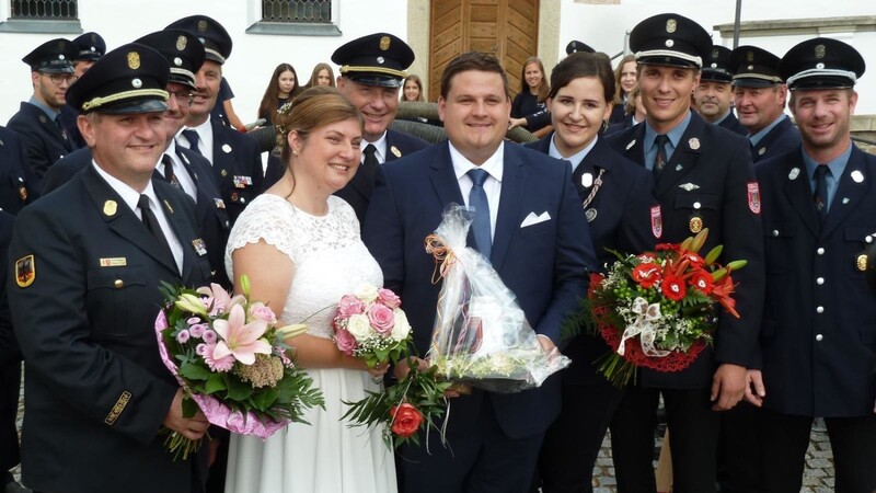 Das Brautpaar mit Gratulanten der Feuerwehr.