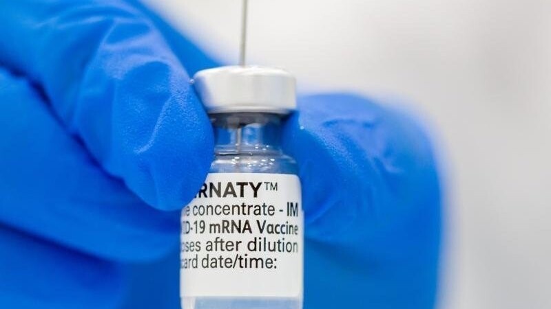 Eine medizinische Fachkraft ein Fläschen mit dem Pfizer-BioNTech-COVID-19-Impfstoff in der Hand.