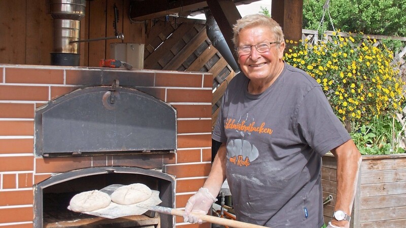 Rudi Forster schiebt die Brote in den Holzofen.