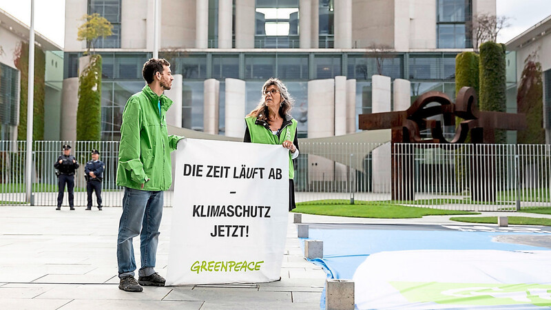 Zwei Greenpeace-Aktivisten protestieren am Donnerstag vor dem Bundeskanzleramt für Klimaschutz.