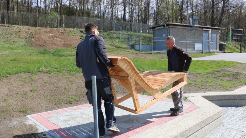 Josef Högerl (re.) und Elias Dikan bringen die neuen Sitzmöglichkeiten, die unter anderem nahe des Sportbeckens aufgestellt werden.
