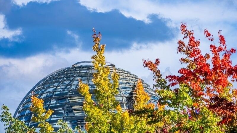Die Kuppel auf dem Deutschen Bundestag hinter bunt gefärbten Laubbäumen. In den kommenden Tagen finden zahlreiche Gespräche über die Bildung der künftigen Regierung statt.