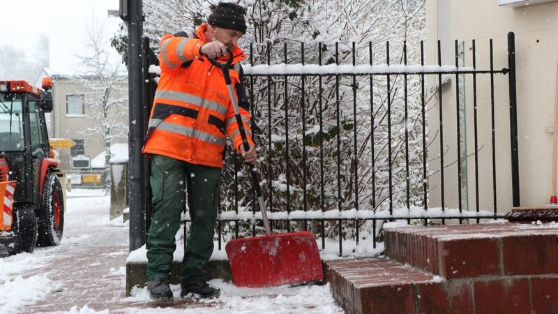 Ein Mann befreit den Gehweg von Schnee und Eis. Nicht nur Mitarbeiter des gemeindlichen Bauhofs sind im Winterdienst im Einsatz. Auch die Anlieger müssen im Winter für sichere Gehwege sorgen.