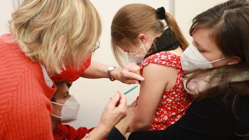 Auf dem Schoß von Mama spürt man den Piks fast gar nicht: Die siebenjährige Pauline bekommt ihre erste Impfung gegen das Coronavirus. Auch in Bayern ist die Nachfrage hoch.