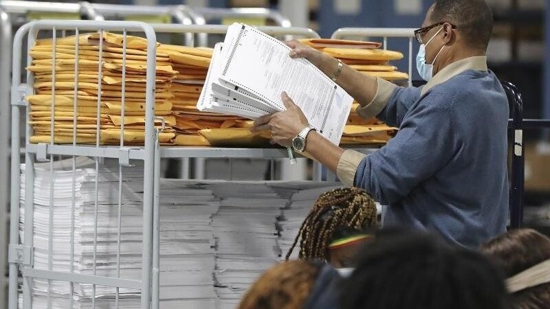 Ein Wahlhelfer sortiert Stimmzettel im Beauty P. Baldwin Voter Registrations and Elections Building in Lawrenceville.