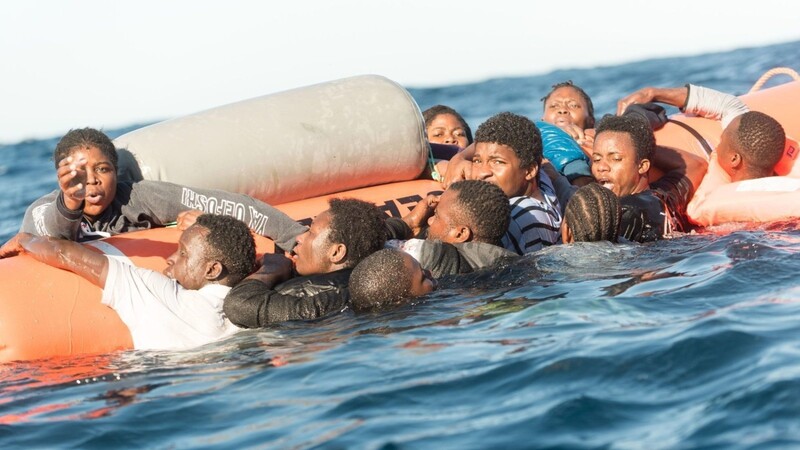 Flüchtlinge in Seenot klammern sich an einen Rettungsschlauch der Hilfsinitiative SOS Mediterranee.