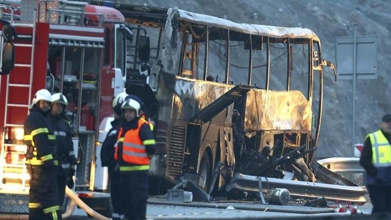 Rettungskräfte der Feuerwehr an der Unfallstelle neben dem ausgebrannten Bus. Bei dem Unglück im Westen Bulgariens starben mindestens 46 Menschen.