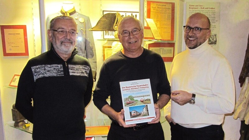 Zusammen mit Stephan Priller, dem Vorsitzenden des Heimatvereins (rechts) und Vorstandmitglied Rudolf Stadlöder präsentiert Karl Bürger (Mitte) das Buch vor der Eisenbahn-Vitrine im Museum.