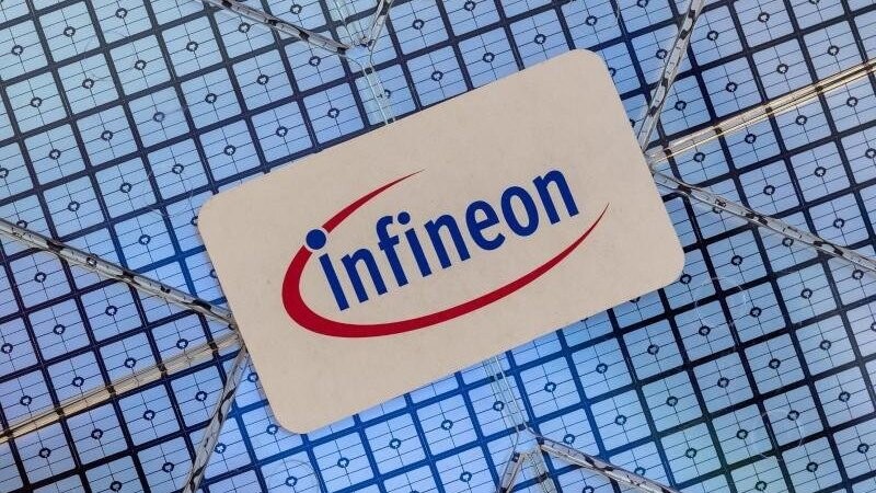 Das Infineon-Logo klebt auf einem Wafer im Showroom des Unternehmens. Foto: Peter Kneffel/dpa/Archivbild