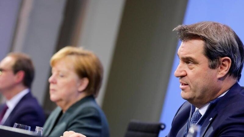 Angela Merkel (CDU), Michael Müller (l, SPD) und Markus Söder (r, CSU), sprechen. Foto: Hannibal Hanschke/Reuters/Pool/dpa