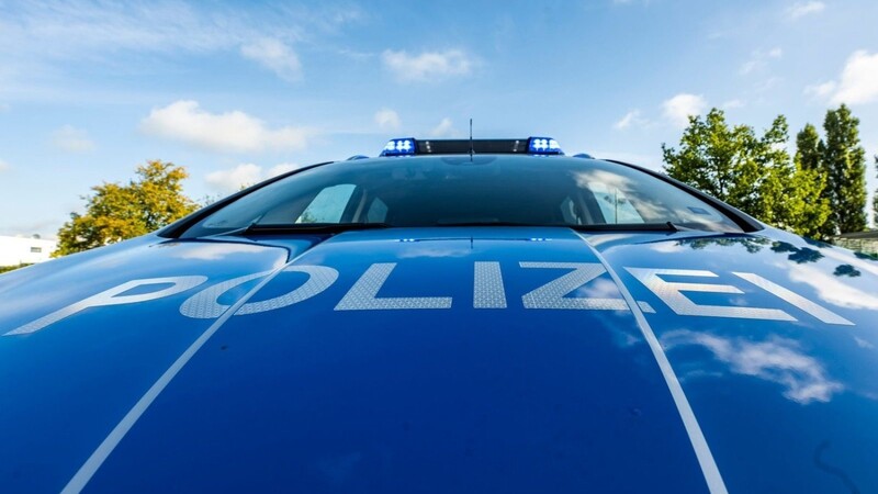 Auf der Motorhaube eines Streifenwagens steht der Schriftzug "Polizei".