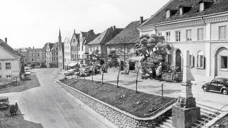 Die Postkarte zeigt den Marktplatz und den Oberen Markt zu Beginn der 1950er Jahre. Am Treppenaufgang stand damals noch das Kriegerdenkmal zum Deutschen Krieg 1866 und zum Deutsch-Französischen Krieg 1870/71, dieses wurde später in den Waldfriedhof am Eingang von der Schäfflerstraße versetzt.
