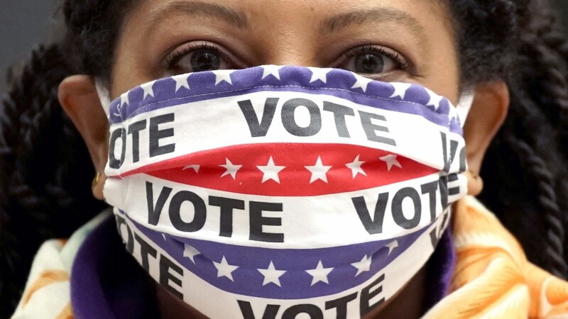 USA, Chicago: Maria Acosta trägt einen Mund-Nasen-Schutz mit der Aufschrift ?Vote? (Wähle!), während sie an einem Frauenmarsch teilnimmt.