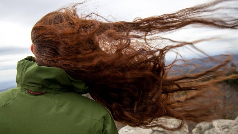 Die Haare einer Frau wehen auf dem Gipfel des Großen Feldbergs im Taunus im Wind zur Seite. Der Sturm erreichte in der Nacht zum Montag auch Bayern.